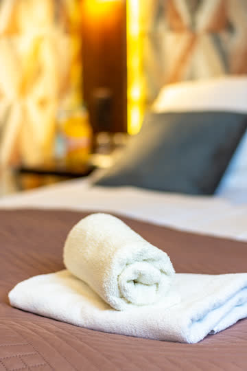 Ręczniki i dekoracja przygotowane na łóżku – Hotel Stara Kuźnia w Kornatce koło Dobczyc