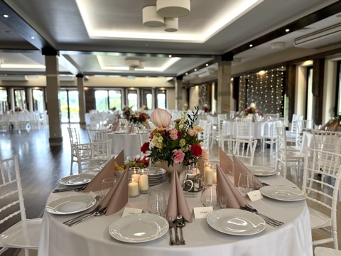 Okrągły stół z kompozycją kwiatową i owocami – Restauracja Stara Kuźnia w Kornatce koło Dobczyc