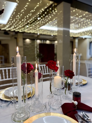 Długi stół biesiadny udekorowany zielenią i różami – Restauracja Stara Kuźnia w Kornatce koło Dobczyc